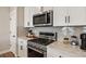 Close-up of the kitchen's sleek stainless steel appliances, including a gas range, and herringbone backsplash at 14096 Red Cosmos St, Parker, CO 80134