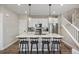 Modern kitchen features stainless steel appliances, white cabinets, quartz counters, and an island with seating at 14096 Red Cosmos St, Parker, CO 80134