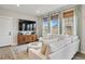 Comfortable living room showcasing a large TV, cabinet, and a plush white sofa with natural light at 14096 Red Cosmos St, Parker, CO 80134