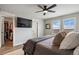 Modern main bedroom featuring a wall-mounted TV, walk-in closet, and bright windows at 14096 Red Cosmos St, Parker, CO 80134