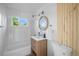 Bright bathroom with modern vanity, new fixtures and a combination tub and shower at 3980 S Hazel Ct, Englewood, CO 80110