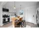 Modern kitchen featuring stainless steel appliances, white cabinets, and a butcher block island with stools at 3980 S Hazel Ct, Englewood, CO 80110