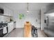 Bright kitchen with white cabinets, stainless steel appliances, and a functional butcher block island at 3980 S Hazel Ct, Englewood, CO 80110