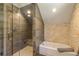 Bathroom with a modern glass shower, bathtub, and stone accent wall at 5724 Highway 9, Breckenridge, CO 80424