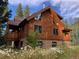 Charming log home with stone accents, set among blooming wildflowers and lush greenery at 5724 Highway 9, Breckenridge, CO 80424