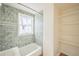 Bathroom featuring a tiled shower, a white bathtub and window with a sheer curtain at 2858 Jasmine St, Denver, CO 80207