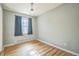 Bedroom featuring hardwood floors, a window with blue curtains, and neutral-colored walls at 2858 Jasmine St, Denver, CO 80207