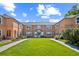 Exterior shot of a red brick apartment building with a spacious lawn and sidewalk in front at 2858 Jasmine St, Denver, CO 80207