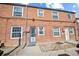 Red brick row home with multiple windows and a secure, gated front door at 2858 Jasmine St, Denver, CO 80207