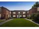 Exterior shot of a red brick apartment building with a spacious lawn and sidewalk in front at 2858 Jasmine St, Denver, CO 80207