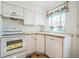 Functional kitchen with white cabinets, neutral countertops, and natural light from a window, featuring an oven at 2858 Jasmine St, Denver, CO 80207
