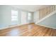 Entryway living room with hardwood floors, and natural light from windows, featuring adjacent staircase with white walls at 2858 Jasmine St, Denver, CO 80207