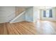 Bright living room featuring hardwood floors, light-colored walls, and a staircase leading to the upper level at 2858 Jasmine St, Denver, CO 80207