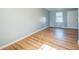 Bright living room with hardwood floors, light walls, white door, and a single window providing natural light at 2858 Jasmine St, Denver, CO 80207
