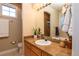 Bright bathroom with granite countertop, plant, and large mirror at 1735 N Ogden St # 106, Denver, CO 80218