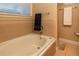 Clean bathroom featuring a soaking tub, decorative tiles, and a window for natural light at 1735 N Ogden St # 106, Denver, CO 80218