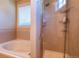 Bright bathroom with a bathtub, glass-enclosed shower, and tiled walls at 1735 N Ogden St # 106, Denver, CO 80218