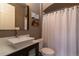 Well-lit bathroom features a vanity with modern sink and faucet, toilet and shower with white curtain at 1735 N Ogden St # 106, Denver, CO 80218