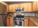 Bright kitchen with stainless steel appliances, wooden cabinets and stone countertops at 1735 N Ogden St # 106, Denver, CO 80218