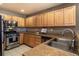 Well-lit kitchen features stainless appliances, wooden cabinets, double sink and tile floor at 1735 N Ogden St # 106, Denver, CO 80218