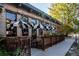 Charming restaurant exterior with striped awnings, lush greenery, and a welcoming outdoor seating area at 1735 N Ogden St # 106, Denver, CO 80218