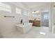 Bright bathroom featuring a standalone tub, double windows, and modern fixtures and wood vanity at 8616 Pennycress Dr, Littleton, CO 80125