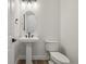 Powder room featuring pedestal sink, sleek fixtures, and modern lighting at 8616 Pennycress Dr, Littleton, CO 80125