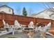 Cozy backyard features a stone fire pit, wooden chairs, a wooden fence, and a beautiful blue sky at 3234 El Charro Pt, Castle Rock, CO 80108