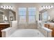 Bright bathroom with soaking tub, dual sinks, and tile surround at 3234 El Charro Pt, Castle Rock, CO 80108
