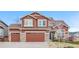 Inviting two-story house featuring a well-kept lawn, stone accents, and a convenient two-car garage at 3234 El Charro Pt, Castle Rock, CO 80108