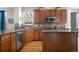 Kitchen featuring stainless appliances, wood cabinets, granite countertops, and hardwood floors at 3234 El Charro Pt, Castle Rock, CO 80108
