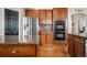 Kitchen featuring granite countertops, wood cabinets, stainless steel refrigerator, and black door at 3234 El Charro Pt, Castle Rock, CO 80108