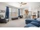Bright living room with ceiling fan, carpet, large windows, and view of open-concept kitchen at 3234 El Charro Pt, Castle Rock, CO 80108
