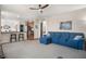 Living room featuring ceiling fan, carpet, and view of open-concept kitchen and dining area at 3234 El Charro Pt, Castle Rock, CO 80108