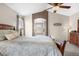 Light filled main bedroom boasts ceiling fan, arched doorway and decorative wall accents at 3234 El Charro Pt, Castle Rock, CO 80108