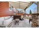Covered patio boasts a hot tub, outdoor seating, privacy, stone columns, and tranquil backyard views at 3234 El Charro Pt, Castle Rock, CO 80108