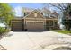 Beautiful two-story home featuring a three-car garage and stone accents, set in a well-manicured lawn at 6462 S Versailles Ct, Aurora, CO 80016