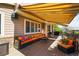Outdoor patio with awning, comfortable seating, and a grill at 6462 S Versailles Ct, Aurora, CO 80016