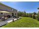 Landscaped backyard featuring a concrete patio with furniture and lush green lawn for outdoor enjoyment at 5090 Miriam Ln, Parker, CO 80134