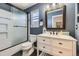 Stylish bathroom with a marble topped vanity, elegant mirror, and a glass enclosed tub-shower at 5090 Miriam Ln, Parker, CO 80134