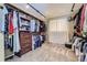 Spacious walk-in closet with custom shelving, hanging rods, and carpet floors for organized storage at 5090 Miriam Ln, Parker, CO 80134