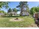 Large backyard featuring a fire pit, green grass, and a home partially obscured by a tree at 7801 Valley View St, Louviers, CO 80131