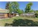 Backyard featuring green grass, a fence, and a shed, ideal for outdoor activities and storage at 7801 Valley View St, Louviers, CO 80131