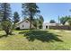 Spacious backyard with a well-maintained lawn, mature trees, a shed, and a charming white house at 7801 Valley View St, Louviers, CO 80131