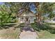 Charming white two-story home with front porch and walkway to the front door surrounded by mature trees at 7801 Valley View St, Louviers, CO 80131
