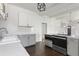 Bright kitchen featuring white subway tile backsplash, gray cabinets, stainless steel appliances, and dark hardwood floors at 7801 Valley View St, Louviers, CO 80131