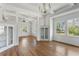Bright open floor plan living area featuring hardwood floors, white walls, built-in cabinets, and many windows at 7801 Valley View St, Louviers, CO 80131