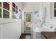 Bright mudroom with white washer and dryer, white walls and trim, lots of natural light, and access to the backyard at 7801 Valley View St, Louviers, CO 80131