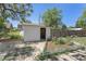 A white shed with an open door, surrounded by green foliage and a white picket fence at 7801 Valley View St, Louviers, CO 80131