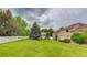 Spacious backyard with lush green lawn, mature trees, and a white picket fence at 6068 W Utah Ln, Lakewood, CO 80232